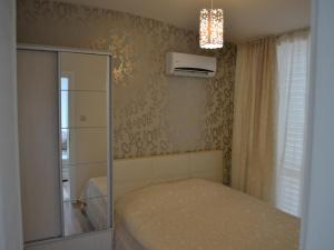 a small bedroom with a bed and a glass cabinet at Peevi Apartments Elit 1 in Sunny Beach