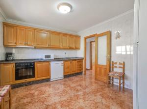 莫萊拉的住宿－Villa Haya - Plusholidays，厨房配有木制橱柜和桌椅