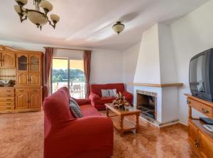莫萊拉的住宿－Villa Haya - Plusholidays，客厅配有红色沙发和电视