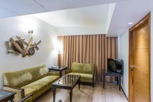a living room with a couch and a tv at The President-A Boutique Hotel in Ahmedabad