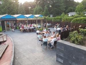 a group of people sitting at tables in a patio at Vakantie veluwe in Wageningen
