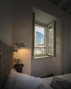 a bedroom with a bed and a window at La Loggia in Chiavenna