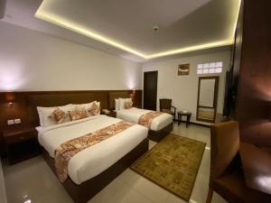 a hotel room with two beds and a television at Grand Mongolia Hotel in Rawalpindi +37 photos