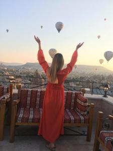a woman in a red dress looking at hot air balloons at Cappadocia Cave Lodge in Göreme
