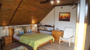 a bedroom with a bed and a desk and a chair at Leśny Domek in Męcikał