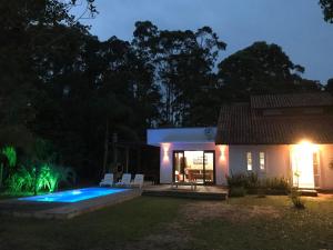 a villa with a swimming pool at night at Morada de Neide in Garopaba