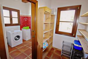 a small bathroom with a washing machine and a window at Finca Argudo - private pool villa in Moraira in Moraira