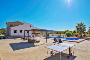 un patio con mesa, sillas y piscina en Finca Argudo - private pool villa in Moraira, en Moraira