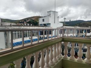 un train blanc sur un pont avec un bâtiment dans l'établissement Pousada Coração de Jesus, à Aparecida