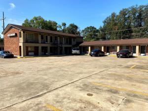 a building with two cars parked in a parking lot at Embers Inn in Winnsboro