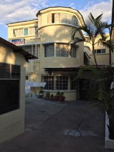 a large building with a palm tree in front of it at Hotel Mayesstic in Guatemala