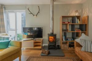 a living room with a wood stove in a room at The Green Lodge Aviemore in Aviemore