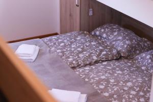 uma cama não feita com almofadas num quarto em Timber Apartment em Bohinj