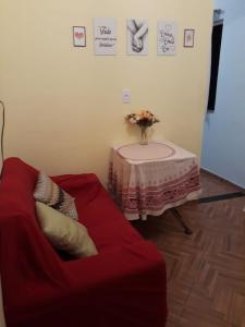 a living room with a red couch and a table at Kitnet novo, completo com AR, 10km da Igreja do Bonfim e 13km do Pelourinho, Centro. in Salvador