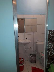 a small bathroom with a sink and a toilet at Kitnet novo, completo com AR, 10km da Igreja do Bonfim e 13km do Pelourinho, Centro. in Salvador