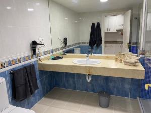 a bathroom with a sink and a mirror at Oasis Fuerteventura Beach Apartments in Corralejo