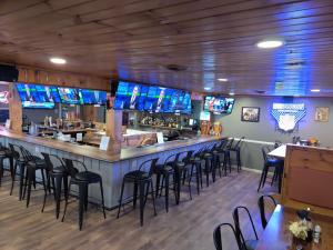 een bar met een aantal televisies aan de muur bij Smoky Falls Lodge in Maggie Valley