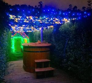 a wooden barrel with a bench in a garden at night at Princess Becfola fairytale cottage in Belfast