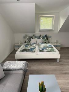 ein Schlafzimmer mit einem Bett, einer Couch und einem Kaktus in der Unterkunft Ossiach Apartment 1 in Heiligen Gestade
