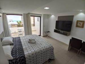 Schlafzimmer mit einem Bett und einem Flachbild-TV in der Unterkunft Gold Flat - Praia do Cabo Branco in João Pessoa