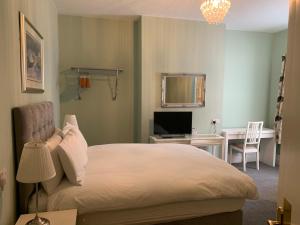 a bedroom with a bed and a desk with a computer at Shrubbery Guest House in Worcester