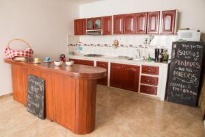 cocina con encimera y nevera negra en Family Host HOSTEL en Villa de Leyva