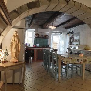 a kitchen with a table with chairs and a refrigerator at Sardinia Retreat Base is your 14th Century home with expert tips in Santu Lussurgiu