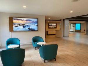 a waiting room with chairs and a painting on the wall at Holiday Inn Portland South/Wilsonville, an IHG Hotel in Wilsonville