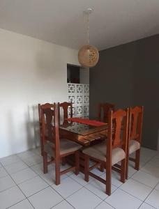 ein Esszimmer mit einem Tisch, Stühlen und einer schönen Beleuchtung in der Unterkunft Residencial Maravilha - Poço in Maceió