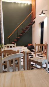 una sala da pranzo con tavoli, sedie e una scala di AHIVÁ Espacio Temporal a Montevideo