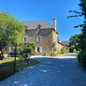 a stone house with a gate and a driveway at Manoir de Beaupré in Vannes