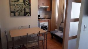 Apartamento pequeño con mesa, sillas y cocina. en Departamento Metro Parque Bustamante, en Santiago