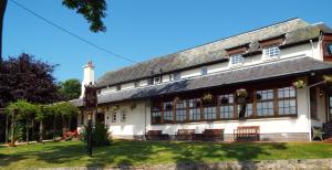 a large white building with benches in front of it at The Inn At Charlestown in Dunfermline