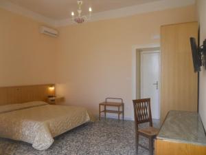 a bedroom with a bed and a table and two chairs at Albergo Santa Teresa in Torre del Greco