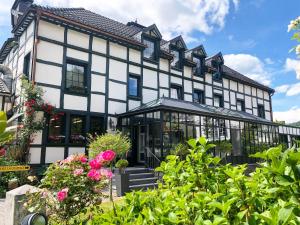 a large white and black building with some flowers at Hostellerie de la Chapelle in Malmedy