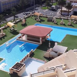 una vista aérea de una piscina con sillas y un edificio en PLAYA MIRAR in Palm Garden, en Morro del Jable