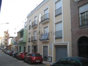 a row of cars parked in front of a building at La Casa Malagueña. in Málaga