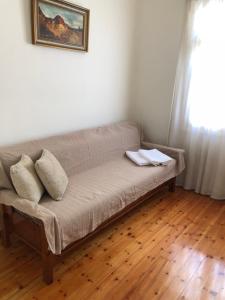 un sofá con 2 almohadas en una habitación en Martha IV, en Amaliás