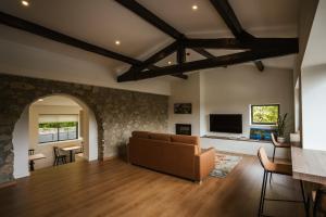 a living room with a couch and a tv at Casa do Engenho Braga - Apartamentos com Vista Rio & SPA in Braga