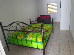 Una cama en una habitación con un verde en Ilet Blanc, en Sainte-Rose