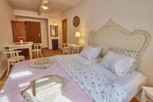 Un dormitorio con una gran cama blanca y una mesa en POD SVATOU ANNOU - penzion a řízkovna, en Horní Maršov
