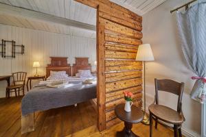 a bedroom with a bed and a wooden wall at POD SVATOU ANNOU - penzion a řízkovna in Horní Maršov