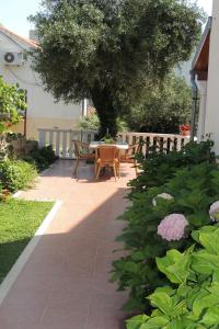a patio with a table and chairs and flowers at Oaza duplex in Dubrovnik