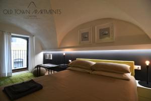 a bedroom with a large bed with an arch above it at Old Town Apartments Catania in Catania