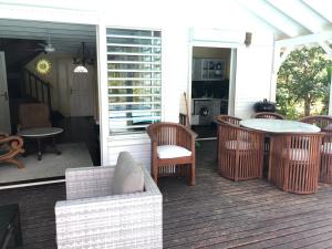 un porche con mesa y sillas en una casa en Villa Laurencin, en Sainte-Rose