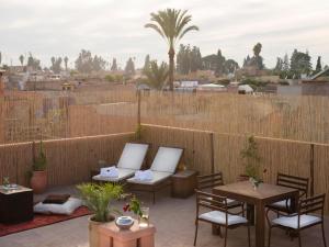 a patio with tables and chairs and a fence at Room in BB - Suite Atlas in luxurious Riad - Marrakech in Marrakesh