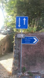 a blue street sign with arrows on a street at The Point - Sintra 3 in Sintra