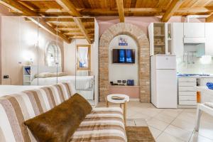 ein Wohnzimmer mit einem Sofa und einer Küche in der Unterkunft Nell'antico ghetto ebraico in Ferrara