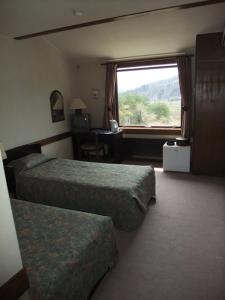 a hotel room with two beds and a window at Guesthouse Sakuya in Fujikawaguchiko