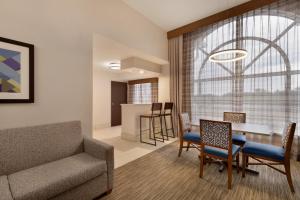 un soggiorno con un divano e un tavolo di Holiday Inn Express Hotel & Suites Auburn - University Area by IHG ad Auburn